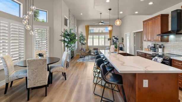 A modern kitchen with a large island, bar stools, pendant lighting, and wooden cabinets. - Scottsdal:  Pool , 2BR/2BTH - Elegant! (Scottsdale)