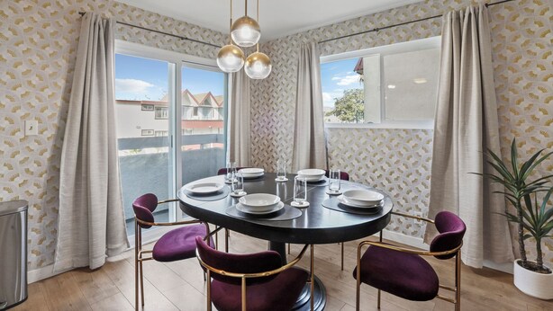A dining area with a round table set for four, purple chairs, and a potted plant. - Charming Condo in the Pico-Robertson area of LA/2-bed + 2.5 Bath/2 Parking spots (Los Angeles)