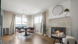 A modern living room with a fireplace, dining area, and a view of the outdoors. - Charming Condo in the Pico-Robertson area of LA/2-bed + 2.5 Bath/2 Parking spots (Los Angeles)