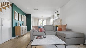 A modern living room with a grey sectional sofa, a white coffee table, and a wooden cabinet. - Charming Condo in the Pico-Robertson area of LA/2-bed + 2.5 Bath/2 Parking spots (Los Angeles)