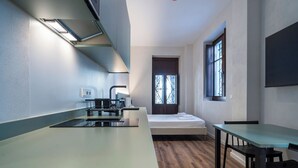 A compact room with a kitchenette, a bed, and a dining area. - VLC HOST - Reina 168 2 (Valencia)