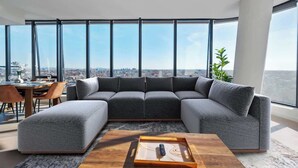 Un salon moderne avec un canapé d’angle, une table basse et un coin repas comprenant des chaises et une table.