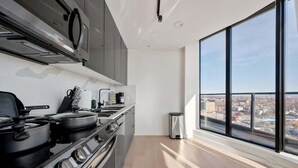 Une cuisine moderne avec une grande fenêtre, une vue sur la ville et une poubelle.