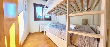Una habitación con literas, ventana con vistas y un radiador.