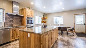 A kitchen with wooden cabinets, a granite countertop, a built-in oven, and a fruit basket. - Brighton Chalet  (Brighton)