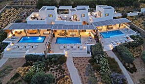 A modern villa with two swimming pools, outdoor seating areas, and a landscaped garden. - Oneiro 4BDR Villa in Antiparos·Sirocco Villa (Antiparos)