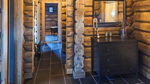 A log cabin interior with a stone wall, a mirror, a dresser, and a tiled floor. - Amazing home in Nissedal with WiFi (Nissedal)