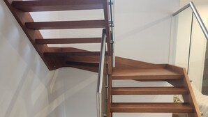 A wooden staircase with metal railings, leading to an upper floor. - Chevron Island Holiday Home (Surfers Paradise)