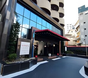 A modern building with a glass facade, a red awning, and a sign reading "GINZA". - APARTAMENTO ACOLHEDOR LIBERDADE SP (São Paulo)