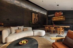 A modern living room with a sofa, coffee table, and dining area. - Charming 2-bedroom villa in the center of Pererenan with Private Pool (Bali)