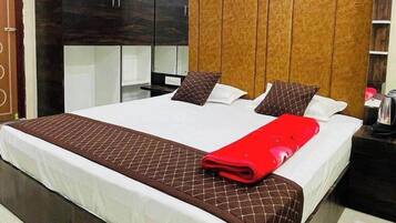 A modern hotel room with a large bed, a ceiling fan, and built-in wardrobes.