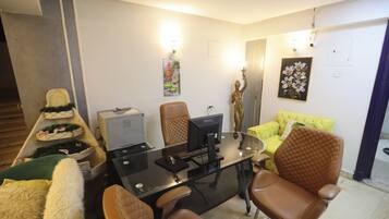 Una sala de estar moderna con una mesa de centro de vidrio, sillones de cuero, un sofá amarillo e impresora.