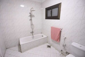 Ein Badezimmer mit Badewanne, Dusche und Toilette.