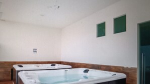 A spa room with two hot tubs and a wooden bench. - Luxury suites polanco  (Ciudad de México)