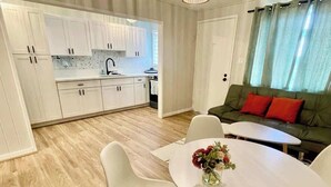 A modern kitchen with white cabinets and a dining area with a white table and chairs.