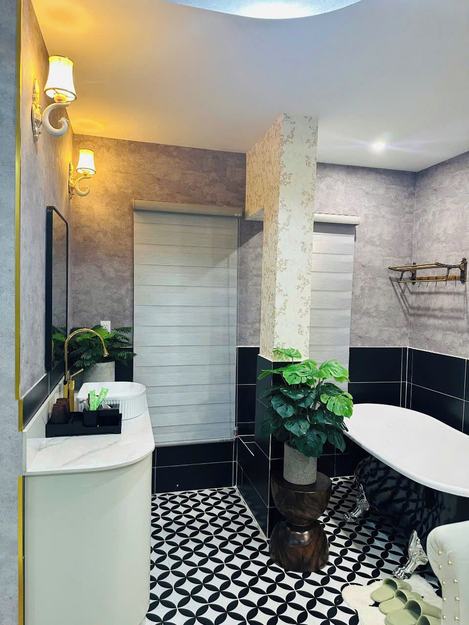 A modern bathroom with a white sink, a large mirror, a toilet, and a bathtub.
