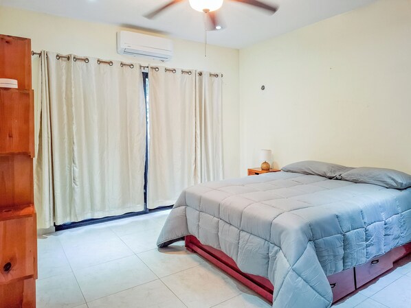 A bedroom with a bed, curtains, a ceiling fan, and an air conditioning unit. - Apt with Pool & jungle in Puerto Morelos (Puerto Morelos)