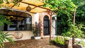 A patio area with a brick floor, a covered seating area, and potted plants. - Apt with Pool & jungle in Puerto Morelos (Puerto Morelos)