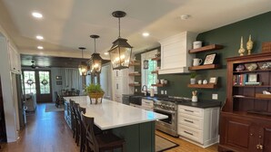 Una cocina moderna con una isla central, sillas de madera y armarios empotrados.