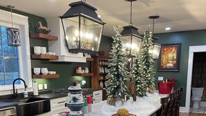 Una cocina moderna con una isla grande, armarios de madera y un árbol de Navidad.