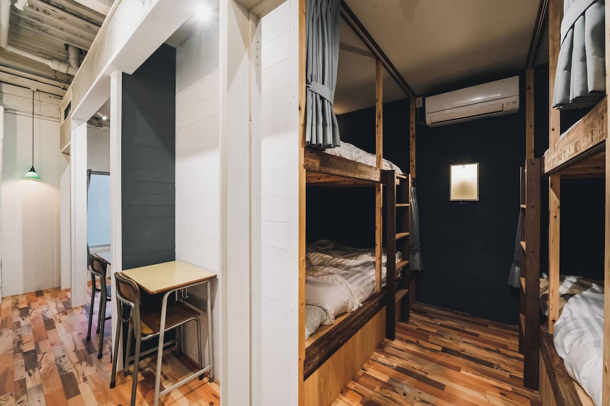 Un dormitorio con literas, un escritorio y una silla.