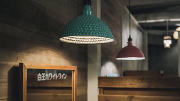 A wooden interior with a green pendant light and a red pendant light hanging from the ceiling.
