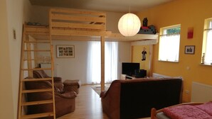 Una habitación con literas, un sofá, un escritorio y una cama.
