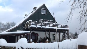 A two-story house with a balcony, surrounded by snow. - Apartment 'Blomberg' with Shared Terrace and Wi-Fi (Meinerzhagen)