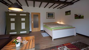 A bedroom with a bed, a wooden ceiling, a green cabinet, and a painting on the wall. - Apartment 'Blomberg' with Shared Terrace and Wi-Fi (Meinerzhagen)