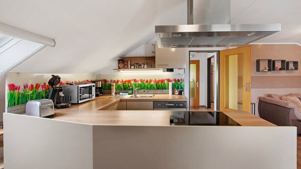 A modern kitchen with a central island, a built-in microwave, and a stainless steel range hood.