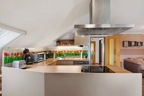 A modern kitchen with a central island, a built-in microwave, and a stainless steel range hood.