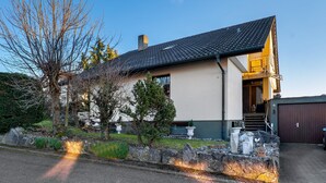 Ein modernes Haus mit Satteldach, Mauerwerk und einem gepflasterten Einfahrt.