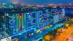 A modern building with illuminated lines and a glass facade, located in an urban setting with a cityscape in the background. - Rocase Hotel Wuxi (Wuxi)