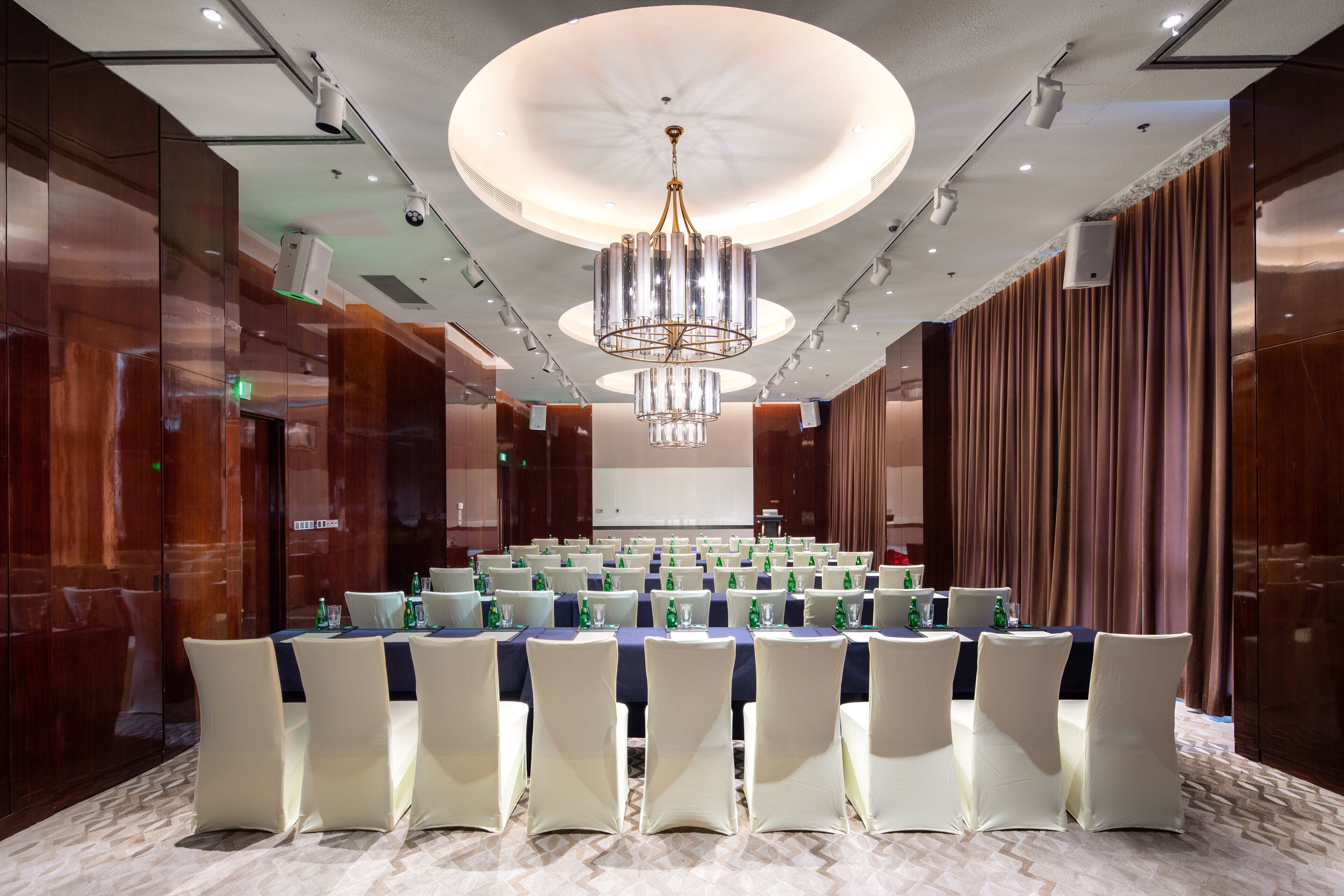 A conference room with a large table, chairs, and a chandelier.