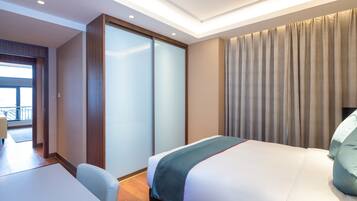 Een moderne hotelkamer met een bed, een bureau en een schuifdeur naar een balkon.