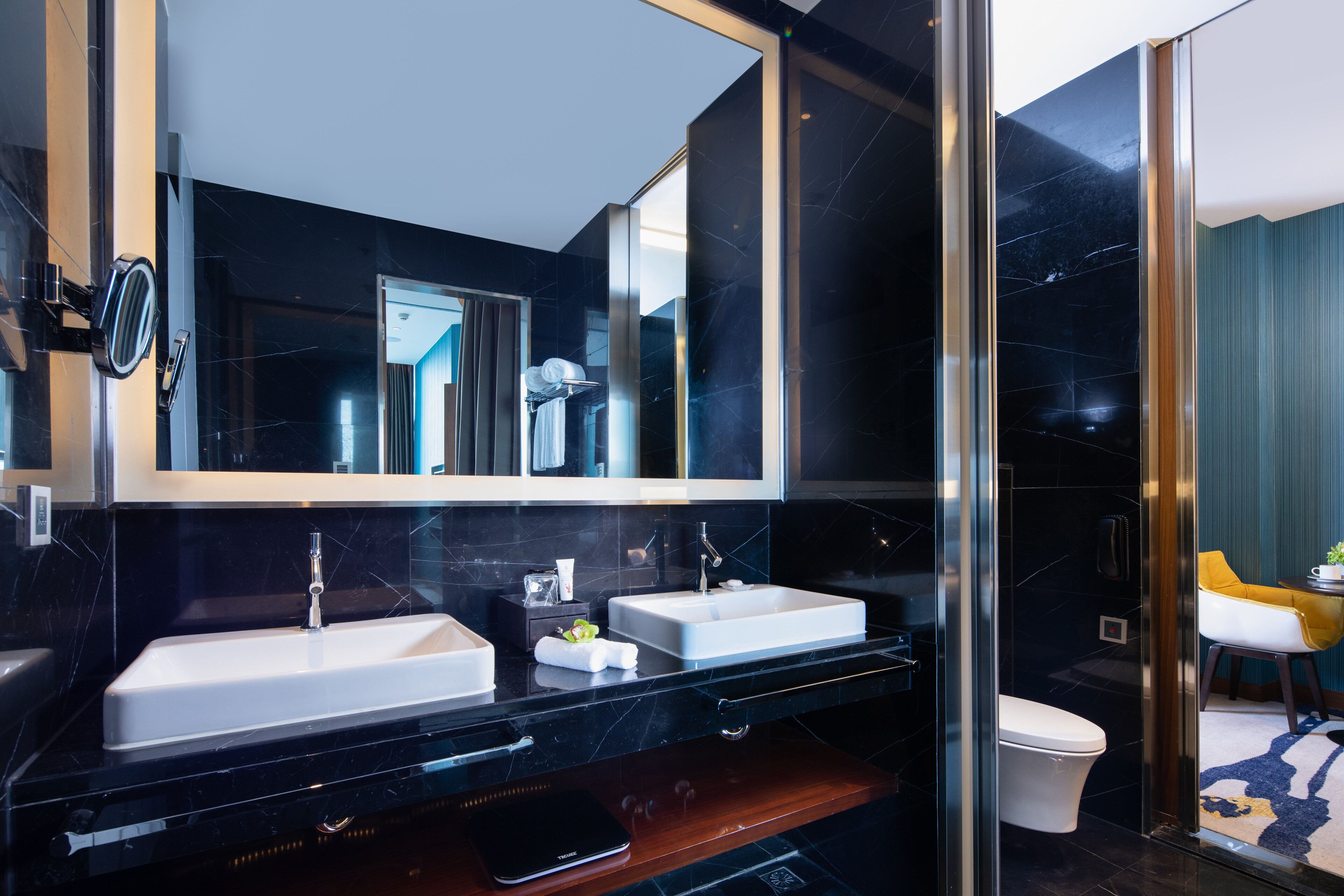 Une salle de bain moderne avec deux lavabos, un grand miroir et une douche à l’italienne.