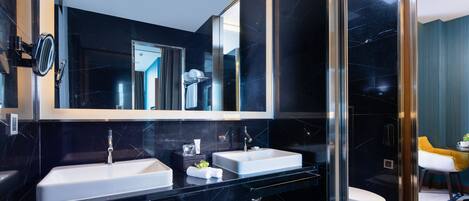 Une salle de bain moderne avec deux lavabos, un grand miroir et une douche à l’italienne.