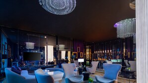 A modern lounge area with plush seating, ambient lighting, and a large flat-screen TV. - Rocase Hotel Wuxi (Wuxi)