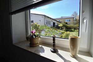 Een uitzicht op een tuin en een gebouw vanuit een raam.