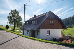 A two-story house with a sloped roof, a small porch, and a visible chimney. - Holiday Apartment 'West' with Shared Terrace, Shared Garden and Balcony (Eisenbach (Hochschwarzwald))