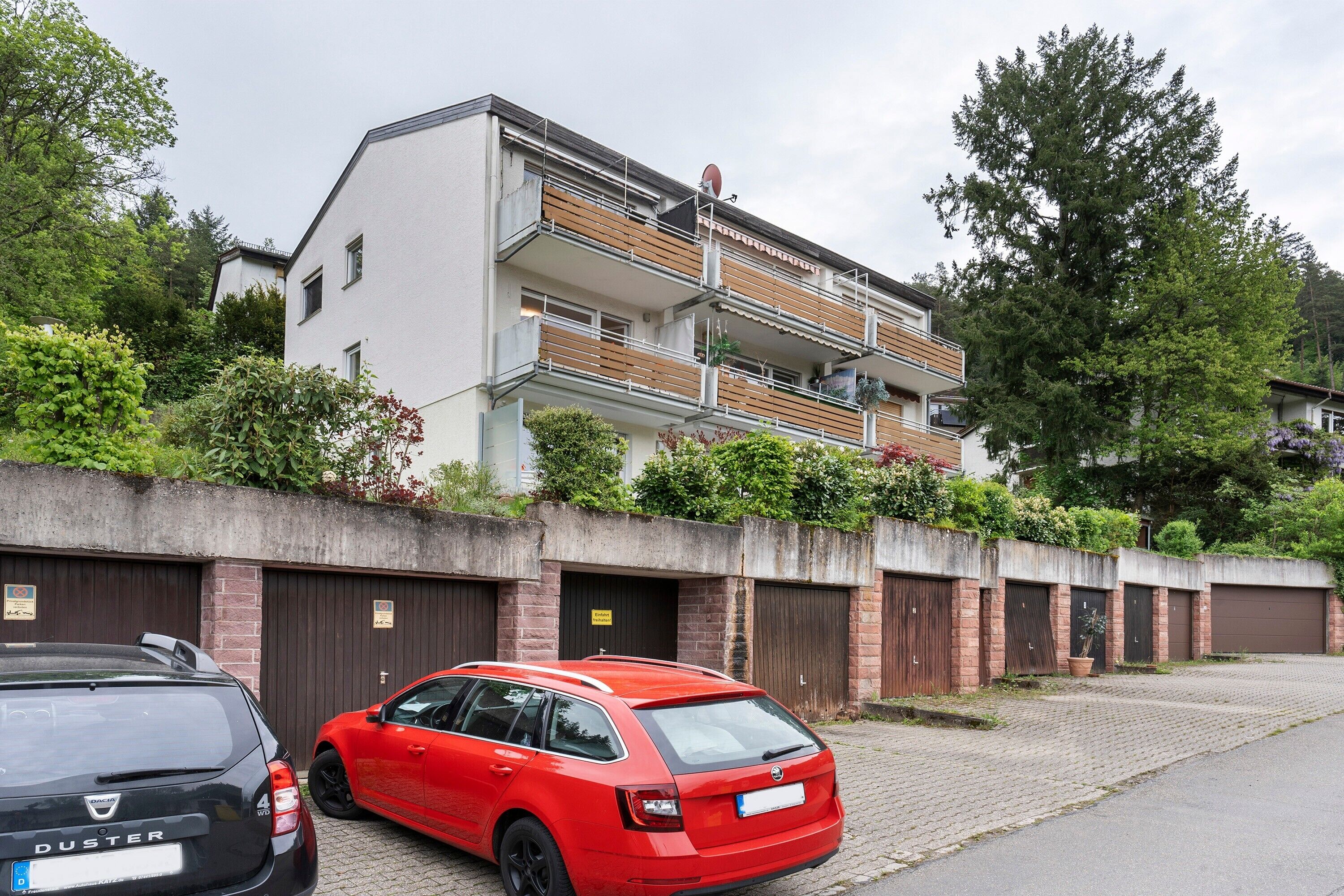 Un edifici residencial amb façana de maó, diversos balcons i un carrer empedrat.