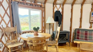 Un ambiente acogedor con una mesa de comedor de madera, sillas, una chimenea y vistas al exterior.