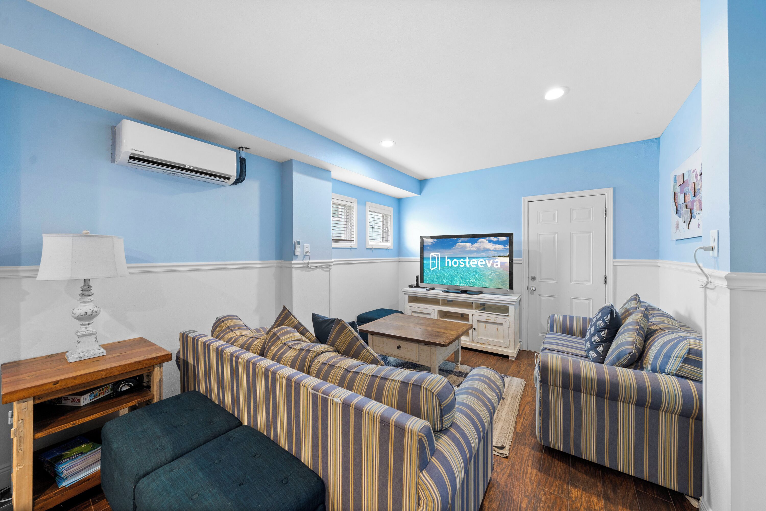 A living room with striped sofas, a TV, and a wooden coffee table.