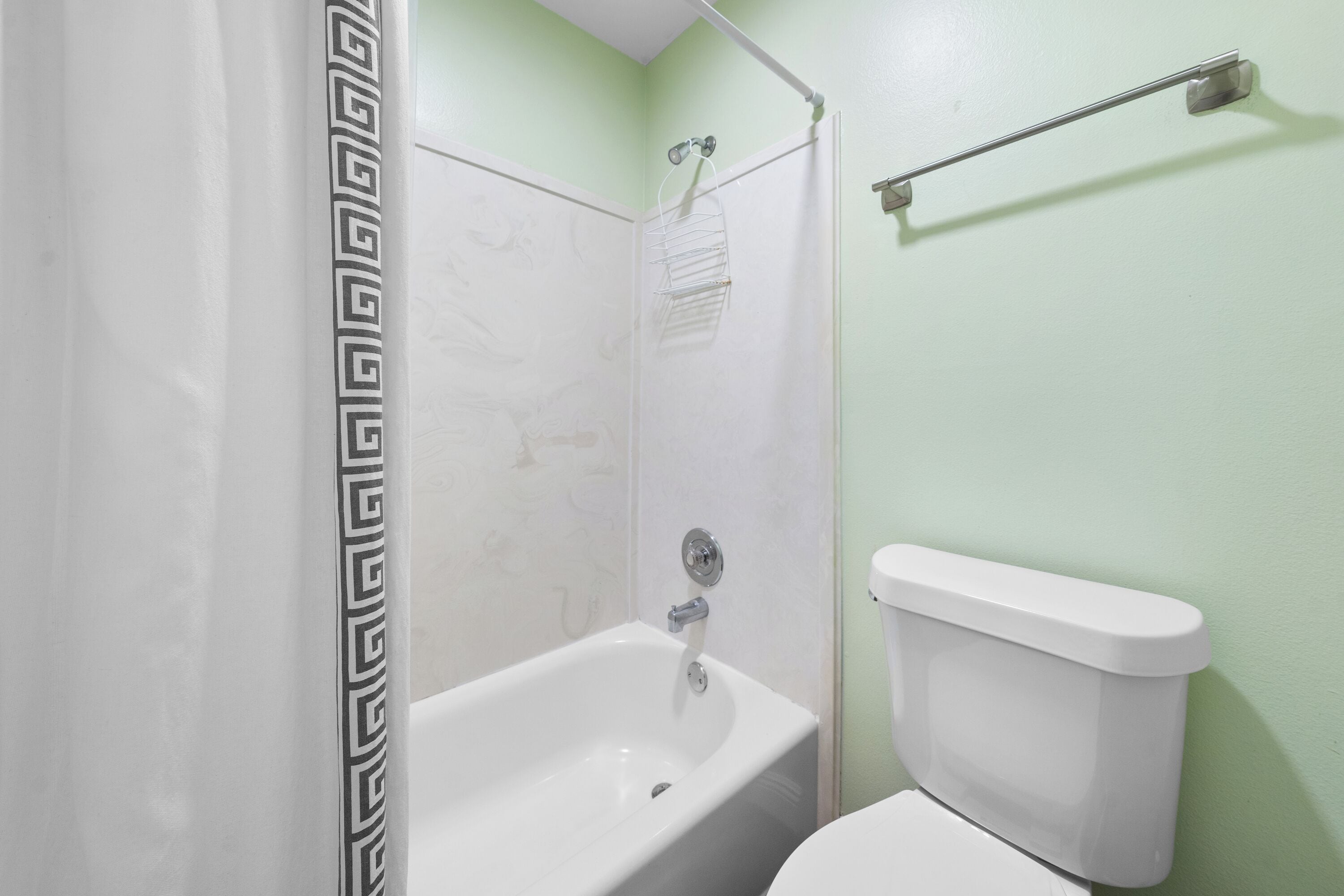 A bathroom with a bathtub, toilet, and shower.