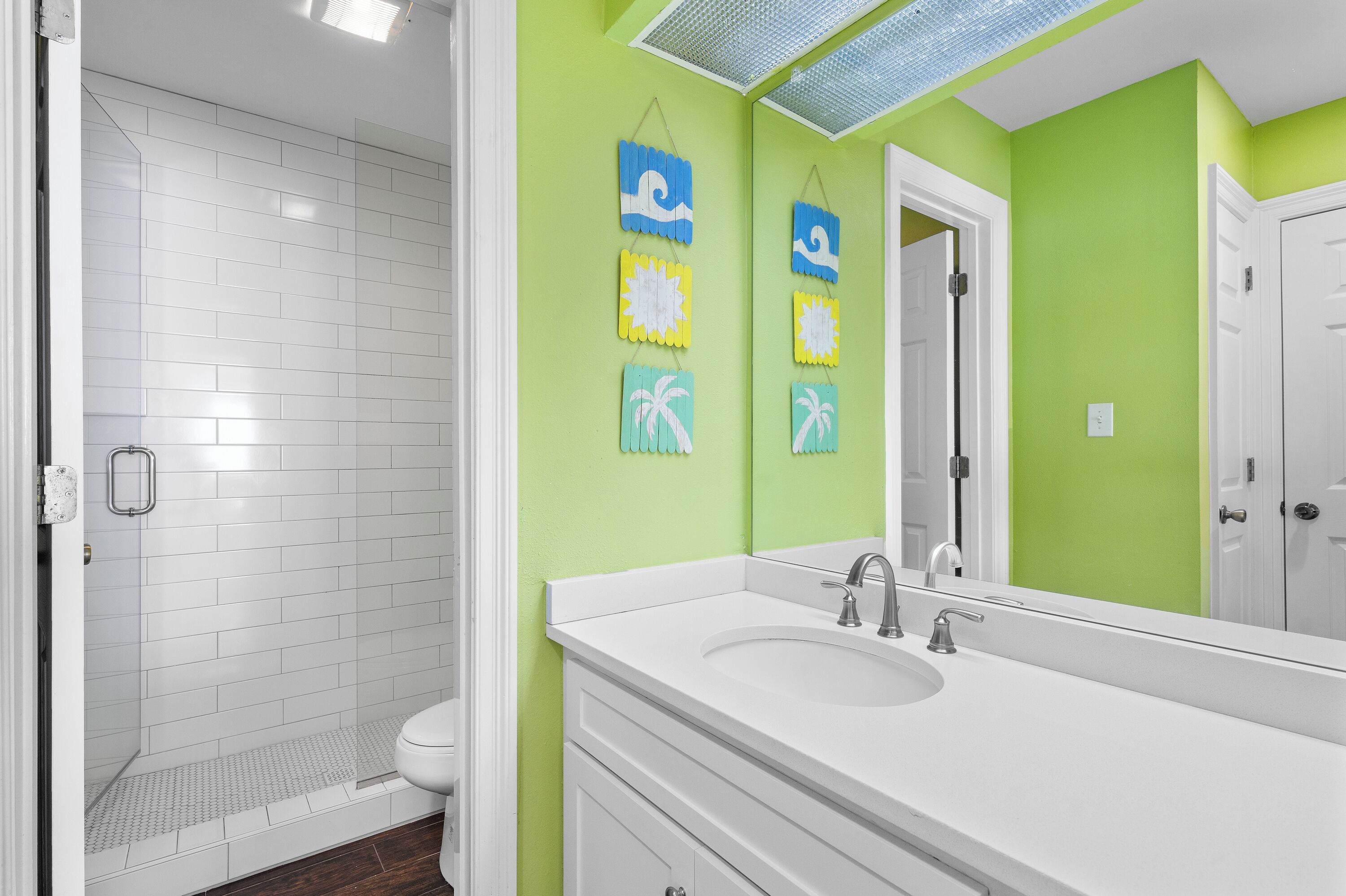 Une salle de bain avec une douche, un lavabo et un miroir.