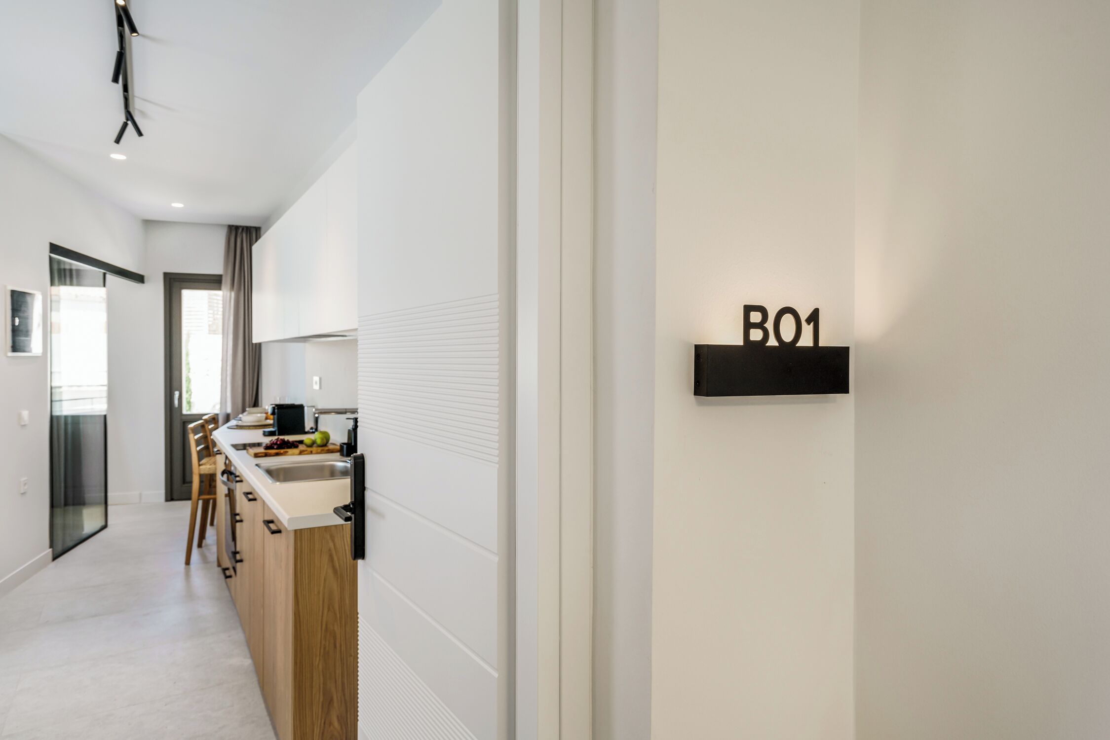Una cocina moderna con encimera de madera, un lavamanos y un armario negro con la etiqueta 'B01'.