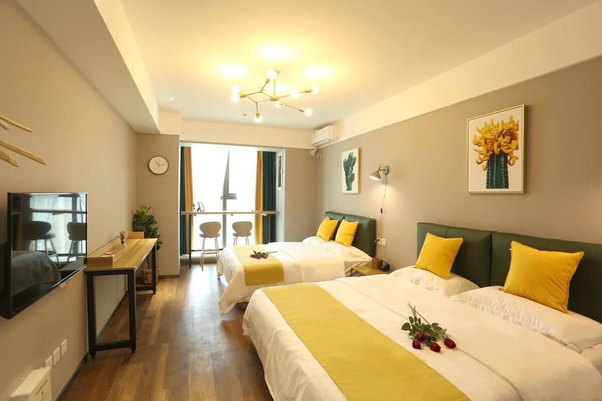 Une chambre d’hôtel avec deux lits, un bureau, une télévision et un balcon avec vue.