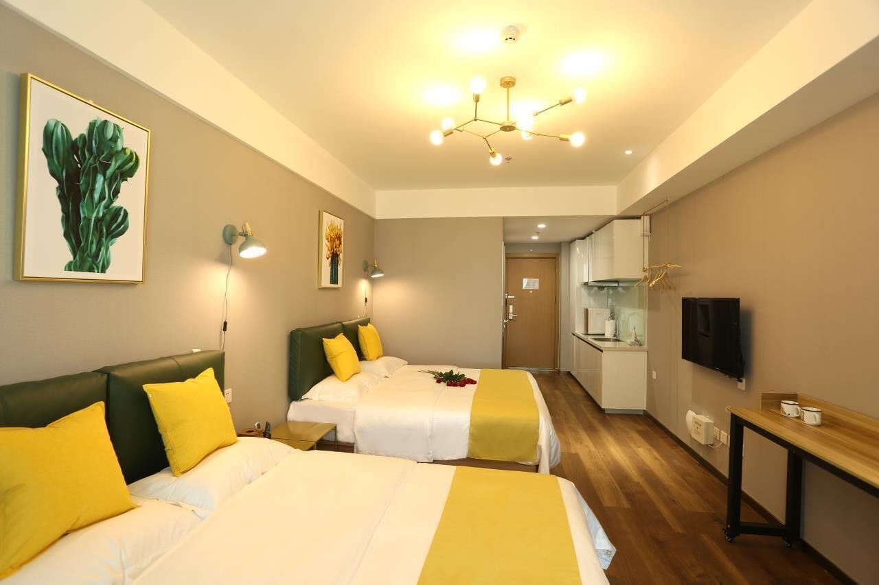 Une chambre d’hôtel avec deux lits, un coin repas et un téléviseur.