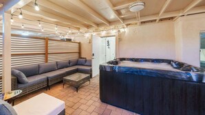 A cozy outdoor seating area with a hot tub, a sofa, and a table. - 3BR 2BA Home w Jacuzzi Near Reid Park & Zoo Unit A (Tucson)