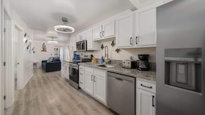 A modern kitchen with white cabinets, stainless steel appliances, and a granite countertop. - 3BR 2BA Home w Jacuzzi Near Reid Park & Zoo Unit A (Tucson)